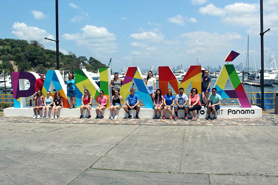 Group of Honors' students behind Panama sign